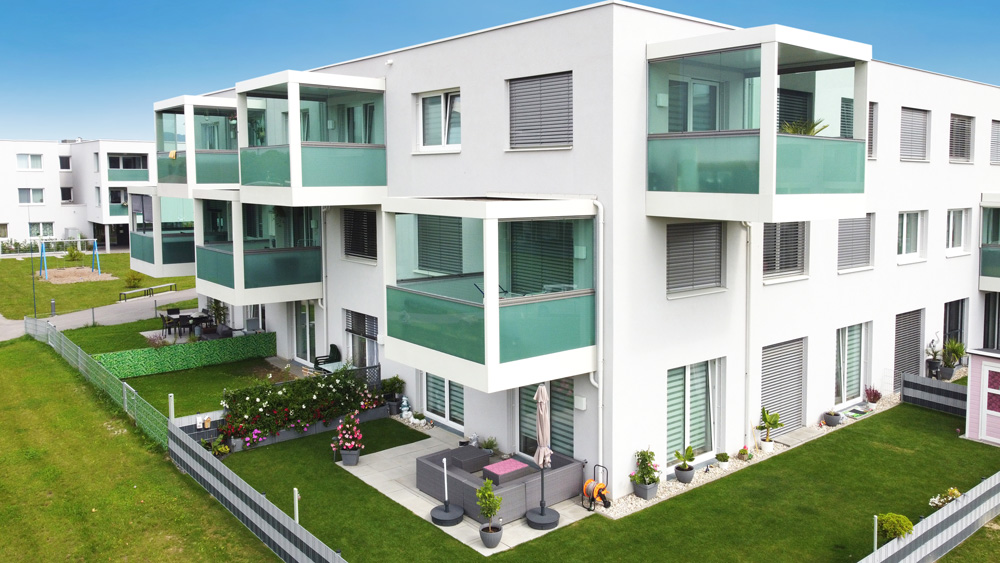 Wohnbau weiß mit kubischen Balkonen, Drohnenaufnahme, Durchfahrtsstraße